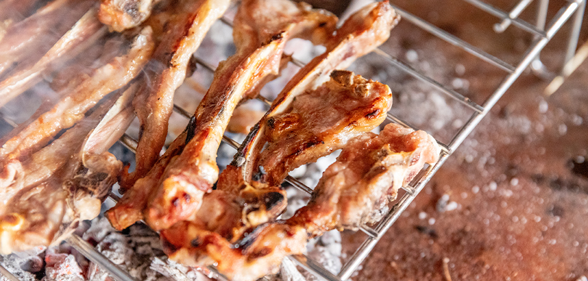 Gegrillte Lammkoteletts auf einem Holzkohlegrill, saftig und knusprig.